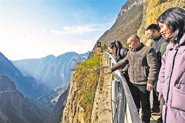 1月11日，巫山縣竹賢鄉(xiāng)下莊村“天路”上，毛相林（右三）給袁孝鑫（右一）等年輕人講述修路的往事。