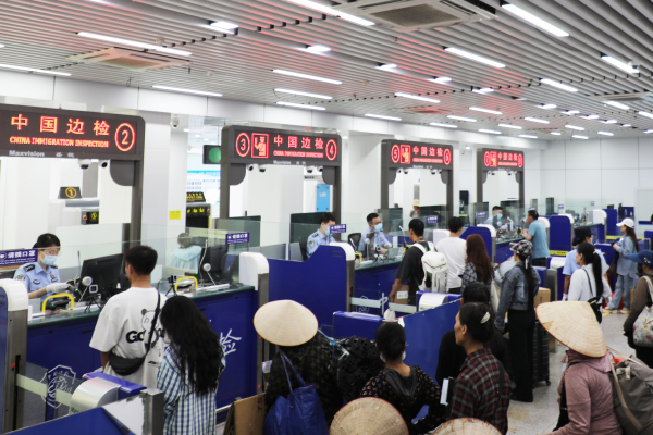 旅客在通道排隊等待查驗通關。周榮寶攝