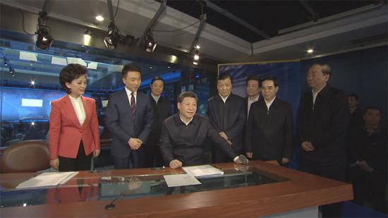 在中央電視臺《新聞聯(lián)播》演播室、導(dǎo)播室，習(xí)近平向主持人和工作人員了解新聞制播流程，并親自切換按鈕體驗?zāi)M播出。