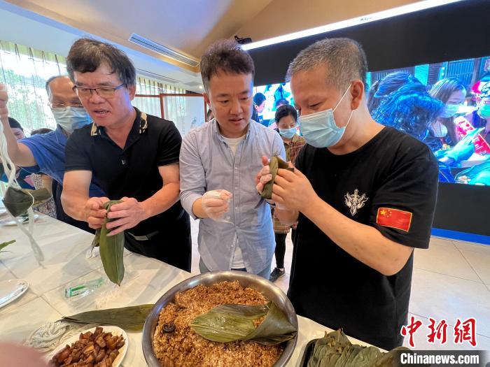 圖為在渝臺胞體驗包粽子?！＄婌?攝