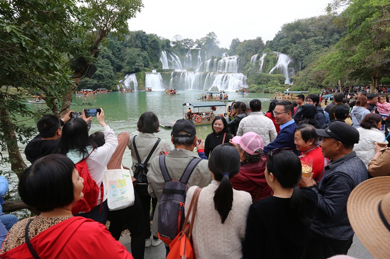 在德天跨國瀑布面前，岸線觀景游人如織。梁婷攝