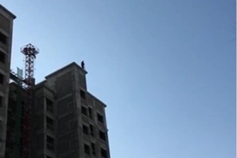 嫌犯在樓頂被發(fā)現(xiàn)，正與警方對峙。視頻截圖