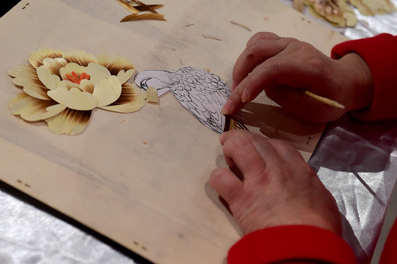  12月2日，在埃及開羅，一名中國(guó)手工藝人在“甘肅文化周”非物質(zhì)文化遺產(chǎn)展上制作秸稈畫。 （新華社記者趙丁喆攝）